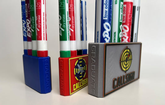 Custom Dry Erase Marker Holders that can have Callsigns, Jet silhouettes, and Side Text added to them. Jets include A-10, F-15, F-16, F-18, F-22, F-35, B-1, B-2, B-52, E-3, Mq-9, T-6, T-8, C-17, C-130, E-8, U-28.  A perfect gift for military pilots. Available in Chisel Tip, Fine Tip and Visa-Vi. Custom Fighter Pilot Squadron Patch Marker Holders, FAIP, Weapons School, Top Gun Graduate